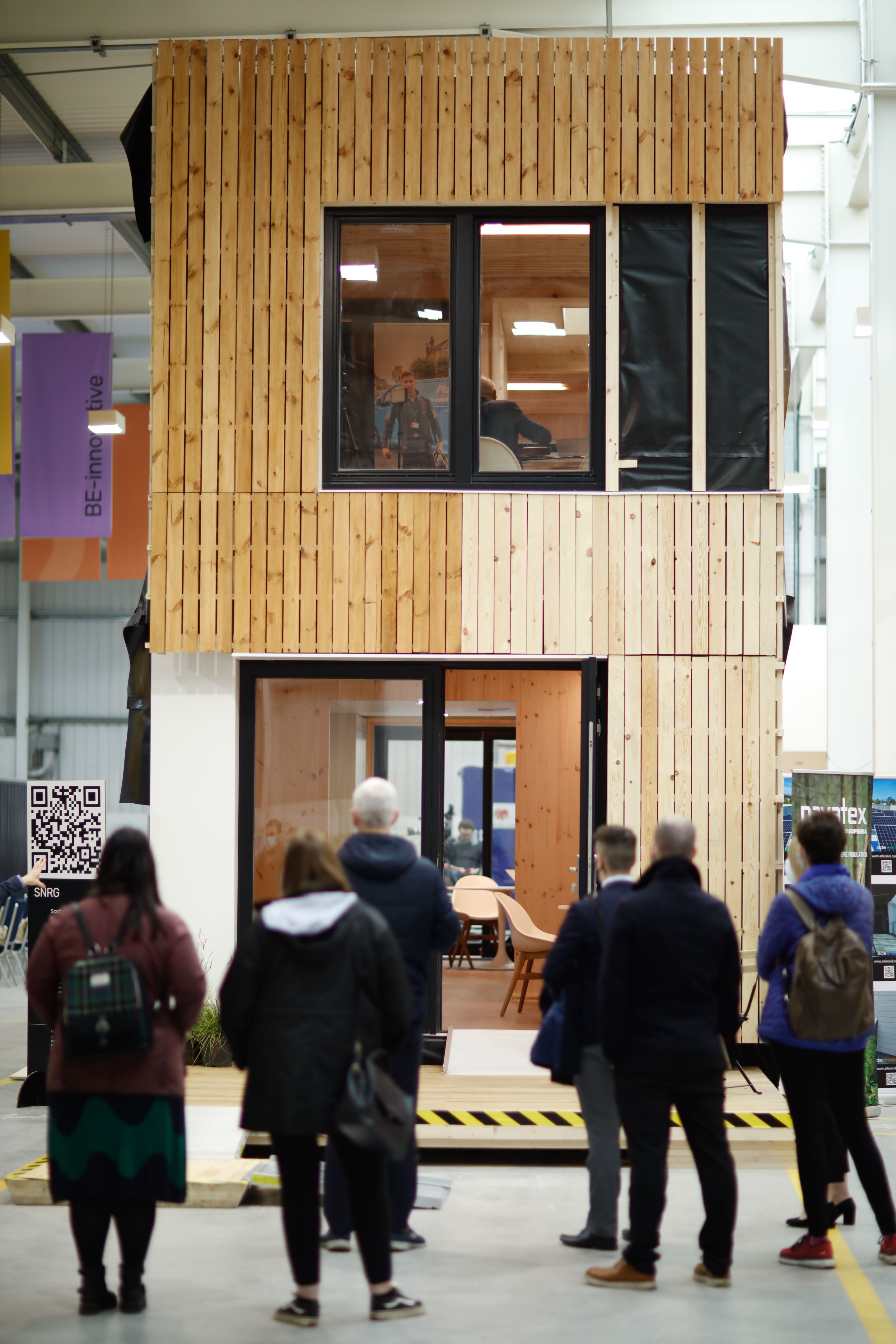 People looking at timber house